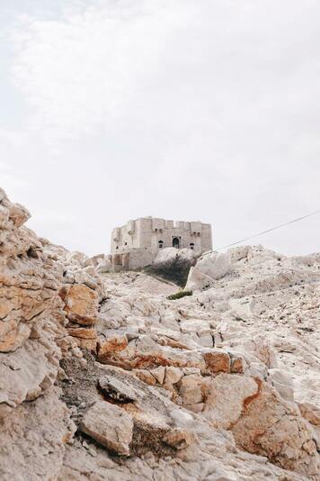 Le Fort de Pomègues, une fortification en pierre, perché sur une colline rocheuse.