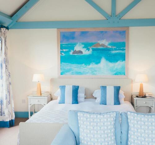 Une chambre d'hôtel décorée avec un tableau d'océan au-dessus d'un lit double.