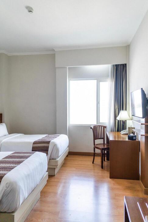 Une chambre d'hôtel avec un lit double, un bureau et un fauteuil.