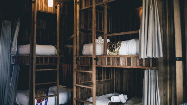 Des lits superposés en bois dans une auberge de jeunesse.